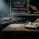 Portada periodística con una parrilla argentina tradicional que tiene un solo corte de carne pequeño y extraño, mientras que en el fondo se ve un cartel de oferta en una carnicería que dice "CARNE DE BURRO - PRECIO POPULAR". Unas manos con anillos ostentosos sostienen un cubierto de plata frente al plato vacío.