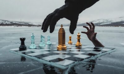Prompt: 16:9, a conceptual image of a chessboard set on a frozen landscape. The pieces are stylized representations of government buildings and natural resources. A large, gloved hand from above is strategically moving a piece in Alberta, while a smaller, desperate hand tries to block the move. The colors are muted—grey, ice blue, and metallic gold. Sharp focus, dramatic lighting, suspenseful and professional editorial design.