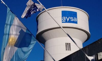 Torre de agua de AySA con banderas, en el marco de la privatización de AySA