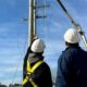 Trabajadores de la empresa realizando tareas de mantenimiento en un poste de electricidad