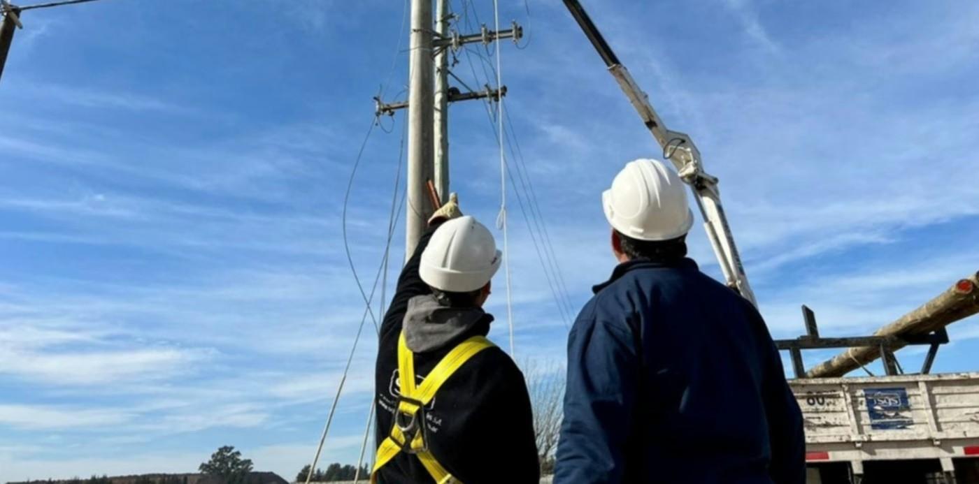 Trabajadores de la empresa realizando tareas de mantenimiento en un poste de electricidad
