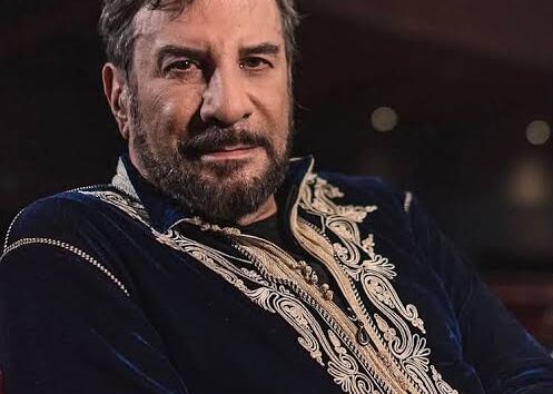 Eugenio Zanetti en un teatro, con una vestimenta bordada, mirando de frente a cámara