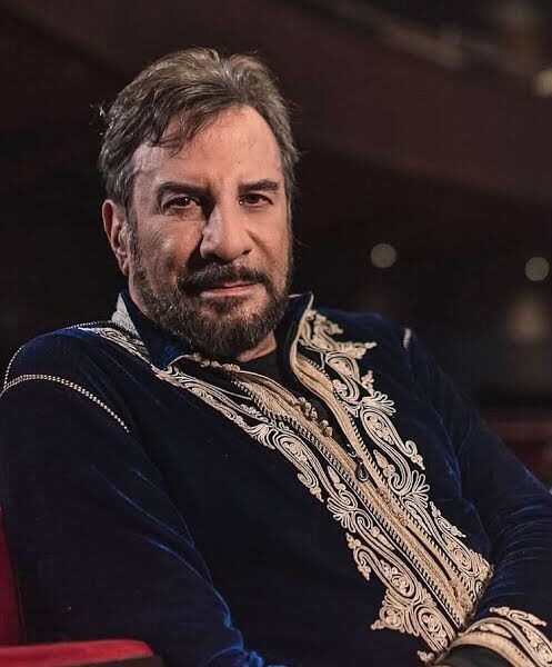 Eugenio Zanetti en un teatro, con una vestimenta bordada, mirando de frente a cámara