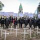 Manifestantes con túnicas negras y máscaras junto a cruces blancas frente al Congreso Nacional