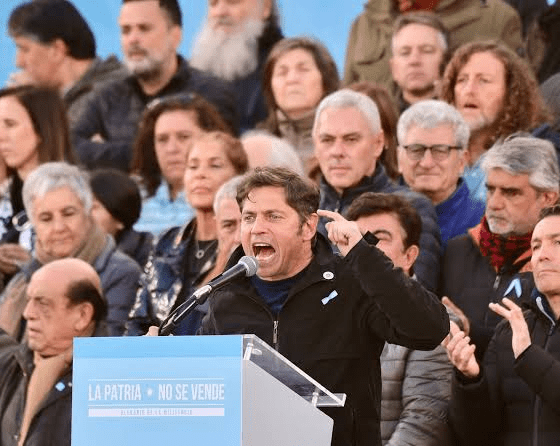 Axel Kicillof habla en un acto con militantes, cartel La Patria No Se Vende
