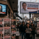 Kiosco de diarios con tapas sobre inseguridad y un cartel de campaña de fondo