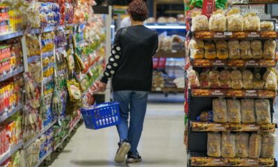 Una mujer camina por el pasillo de un supermercado con un canasto de compras, en el marco del dato de inflación de septiembre